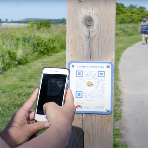 scanning a directions marker with a phone on a durham trail