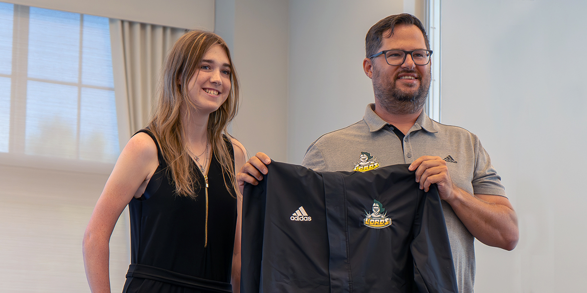 Ashley Green and Scott Dennis hold up a DC jacket.