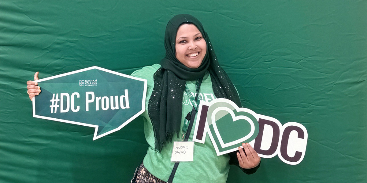 Mourin Moyen is pictured holding a #DCProud sign and a and I love DC sign.