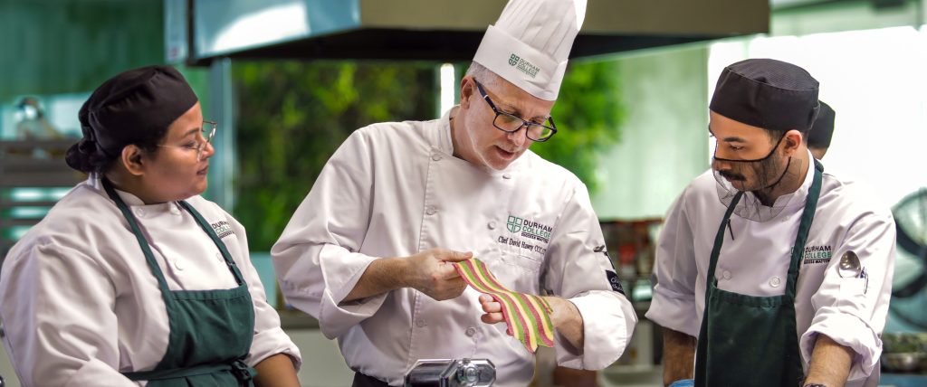 Faculty member showing culinary students a sheet of pasta in the Centre for Food