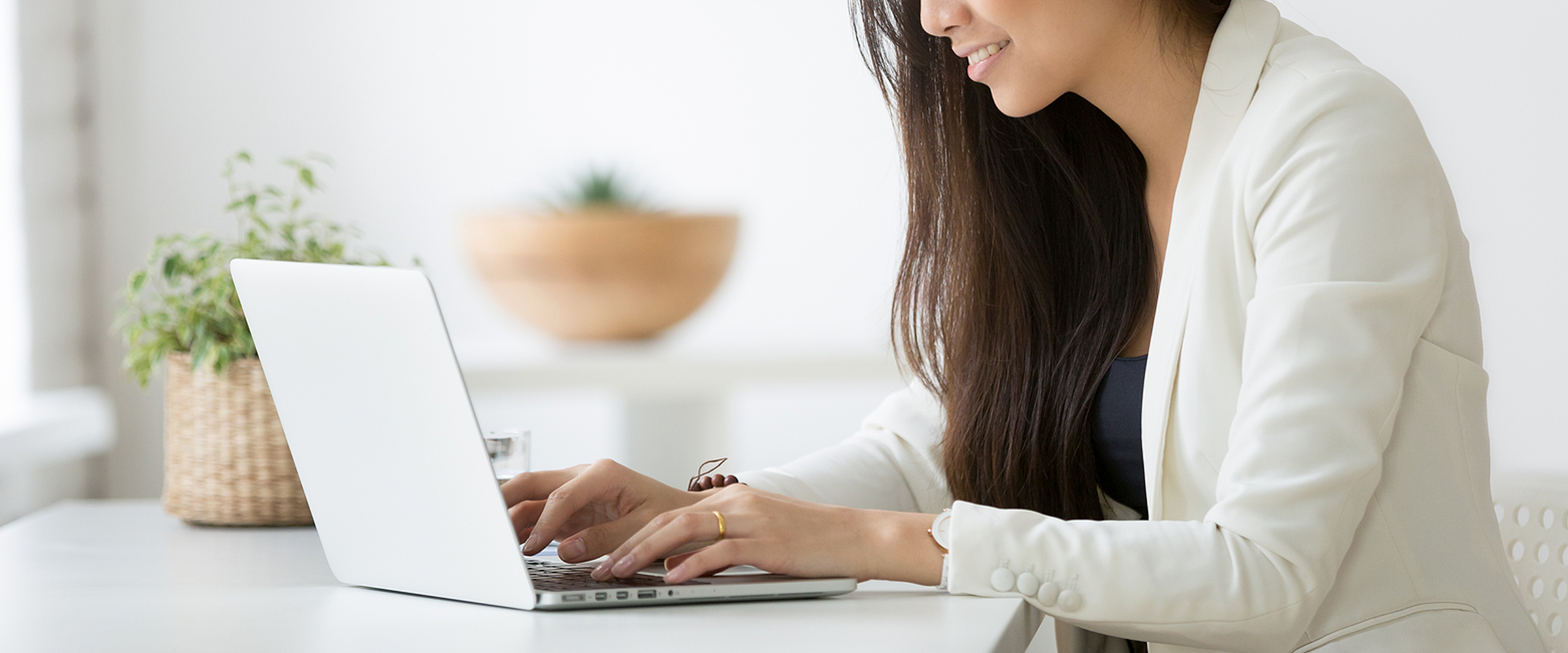 Woman using a laptop at a desktop.