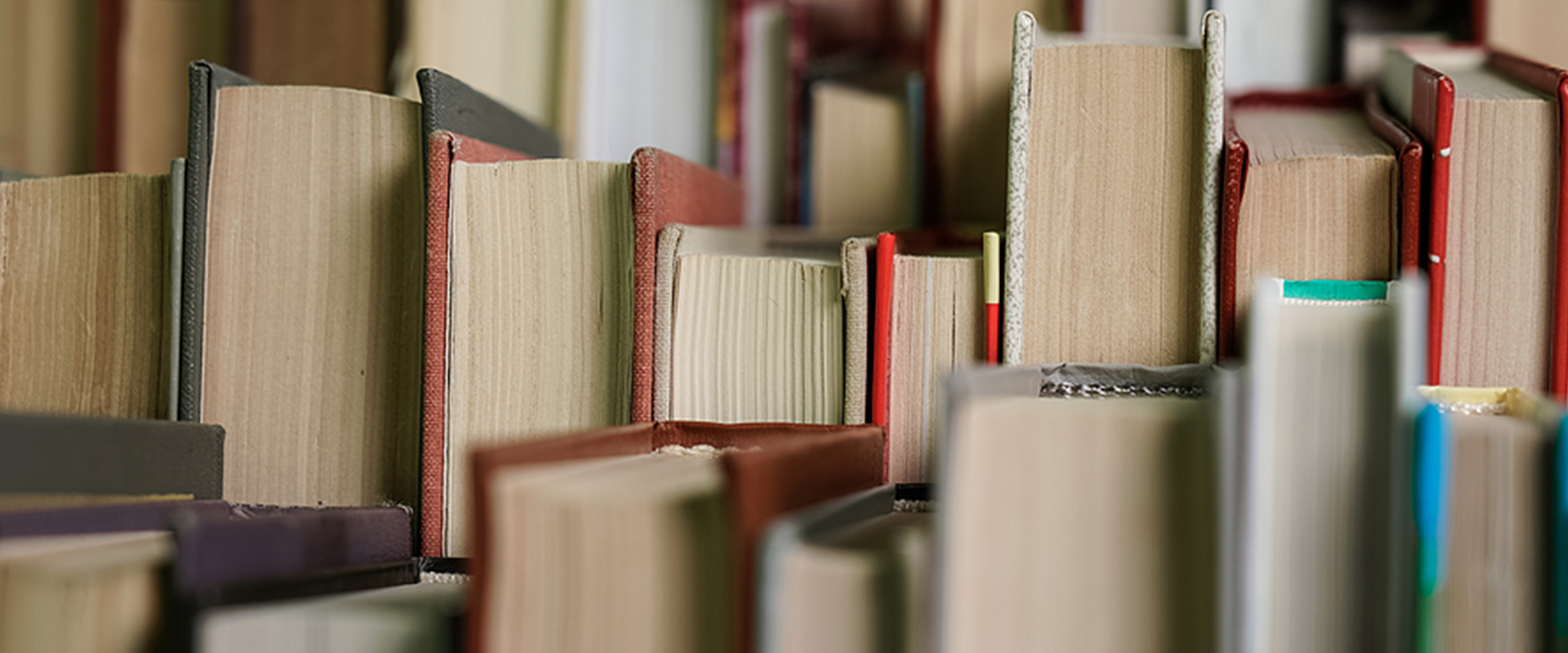 Several closed books, aligned with the page side facing the camera.