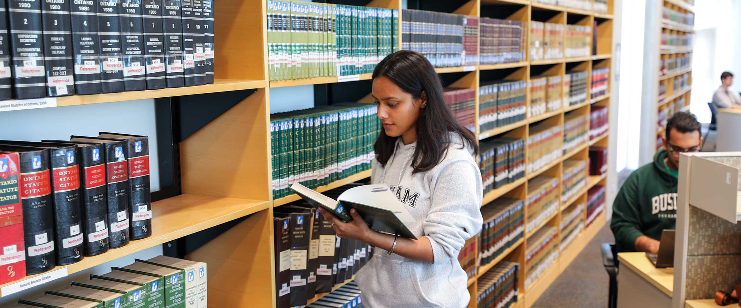 Student looking at a book in the DC library.