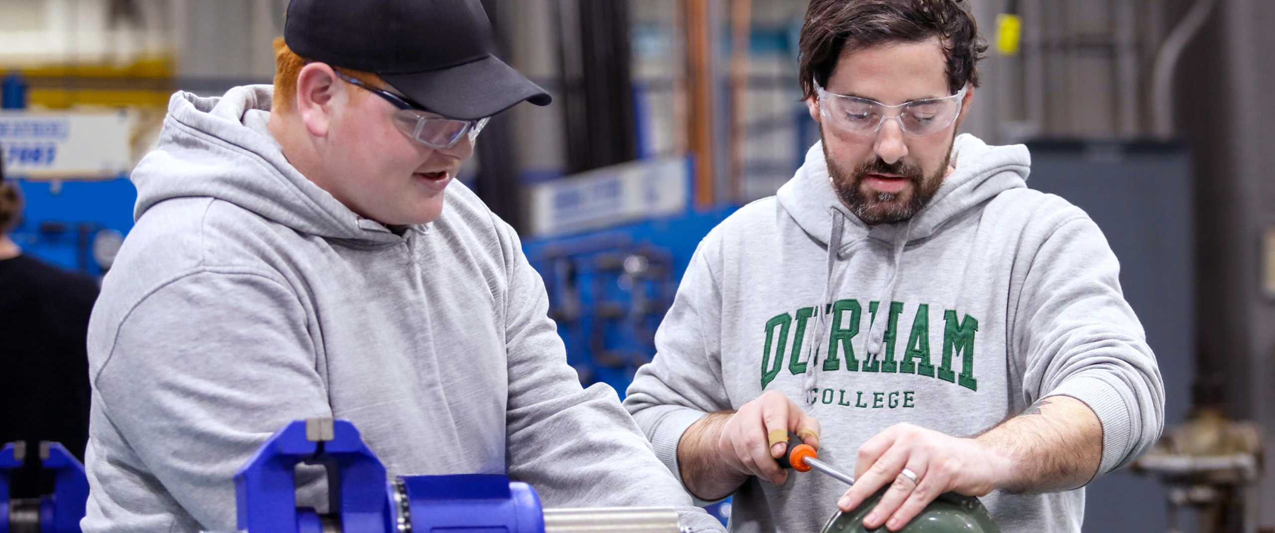 Students in the Whitby shop area working with tools and parts.