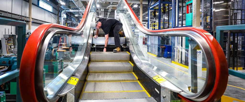 Student repairing an escalator in the Whitby campus shop area.
