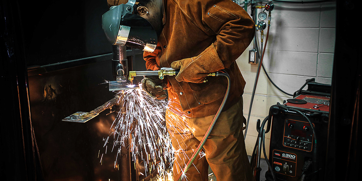 A welder welding a piece of metal
