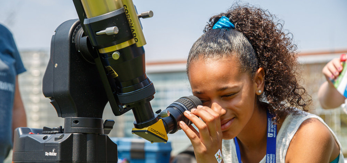 A budding scientist looks through a telescope at DC and UOIT's science rendezvous