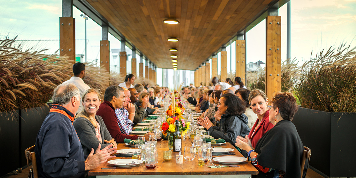 Faculty sit down for Harvest Dinner in front of Bistro 67
