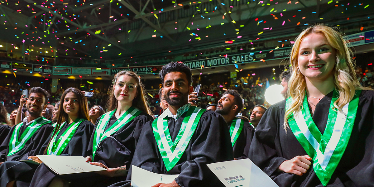 Graduates smile in their seats while attending the convocation ceremony