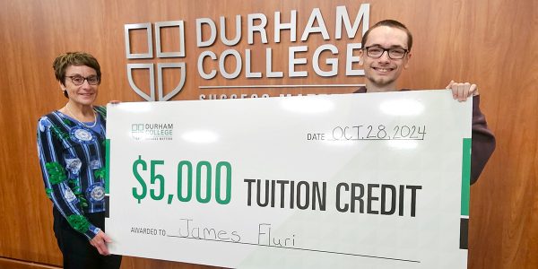 Dr. Elaine Popp and Police Foundations student James Fluri hold an over-sized cheque for $5,000.