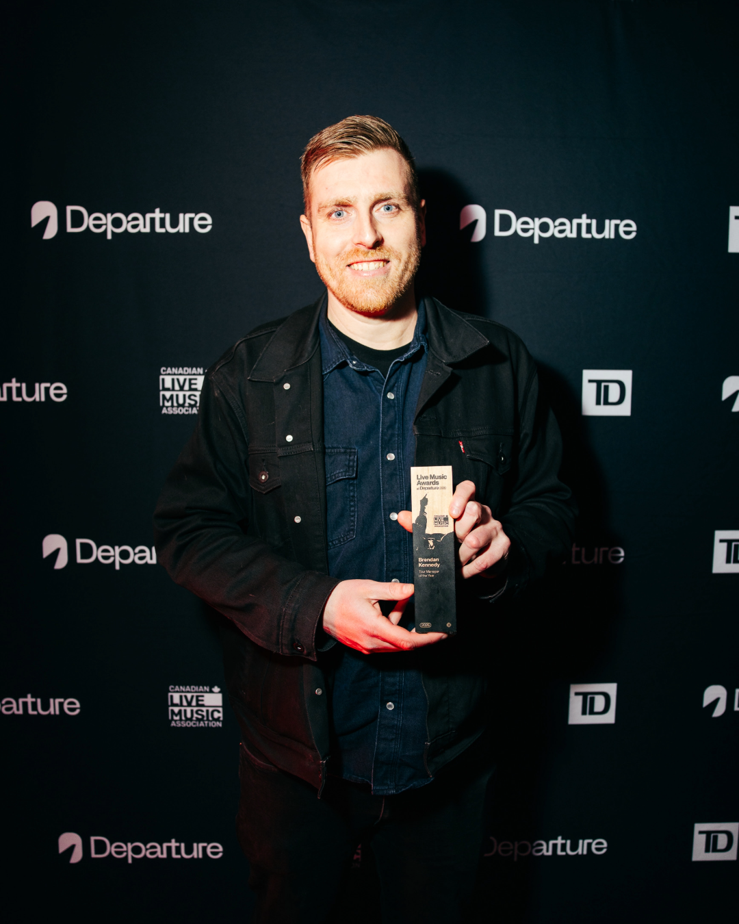 Brendan Kennedy holding his award at the Canadian Live Music Industry Awards.