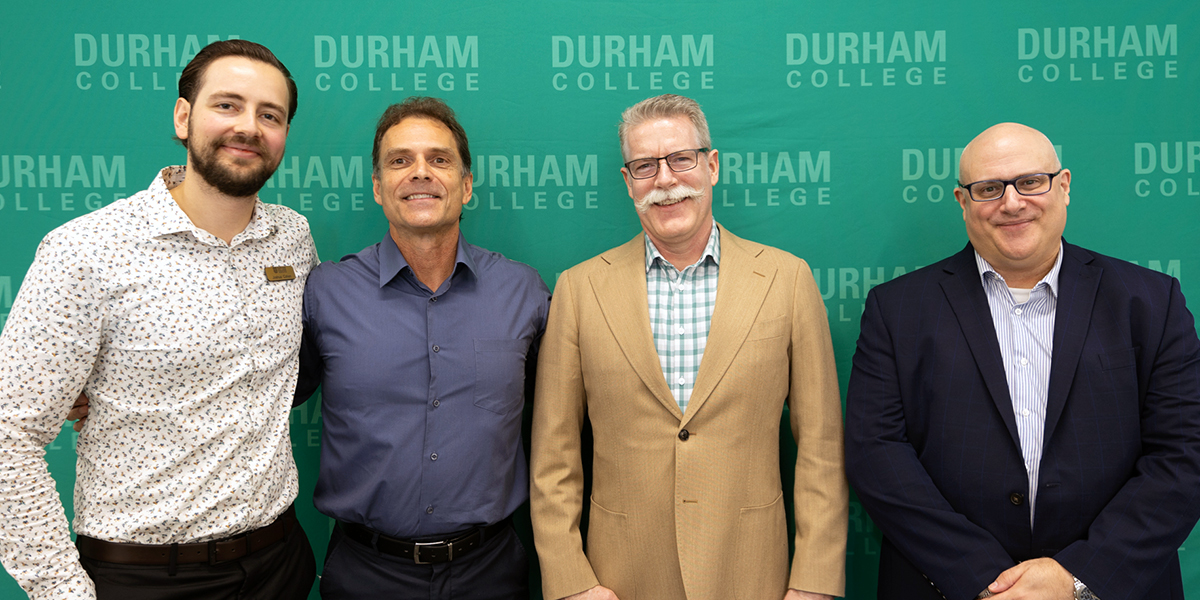 Durham College IP Tech Talk panellists and moderator pose for a photo in front of a green DC media wall