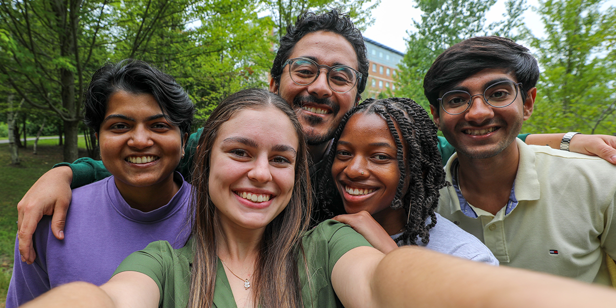 Students pose for a selfie and smile.
