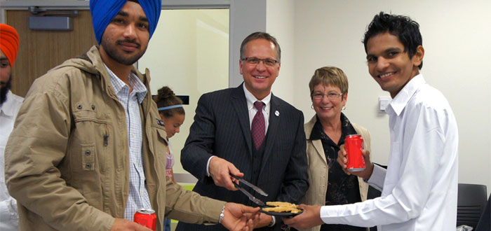 Durham College President Don Lovisa serves students traditional Indian food.