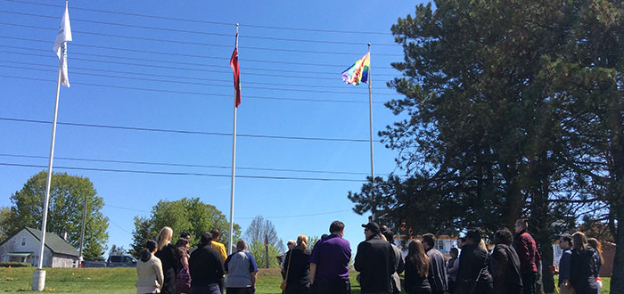 Students watching the pride flag being raised at the Oshawa campus for the first time.