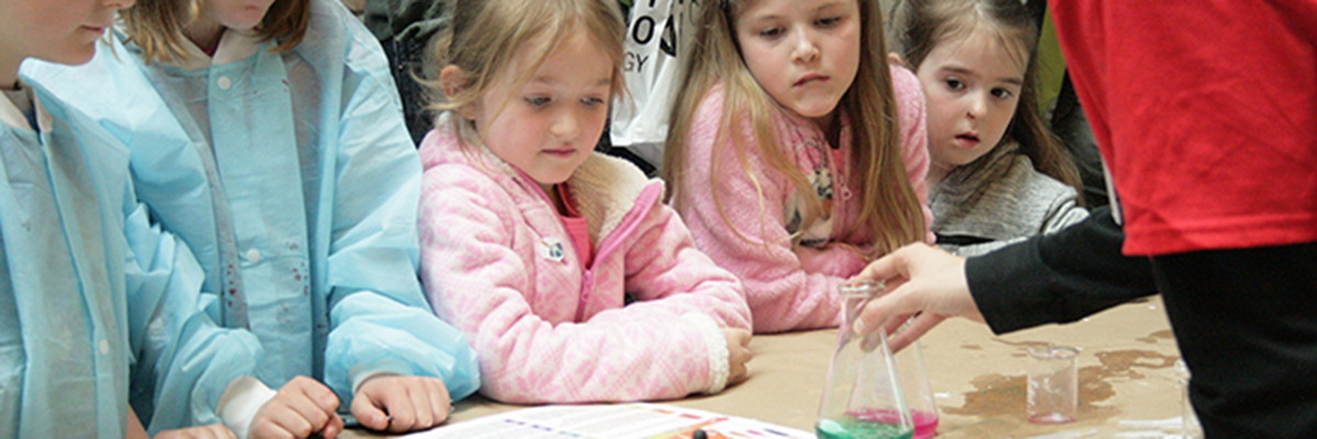 A group of young girls at the Science Rendezvous watching an experiment