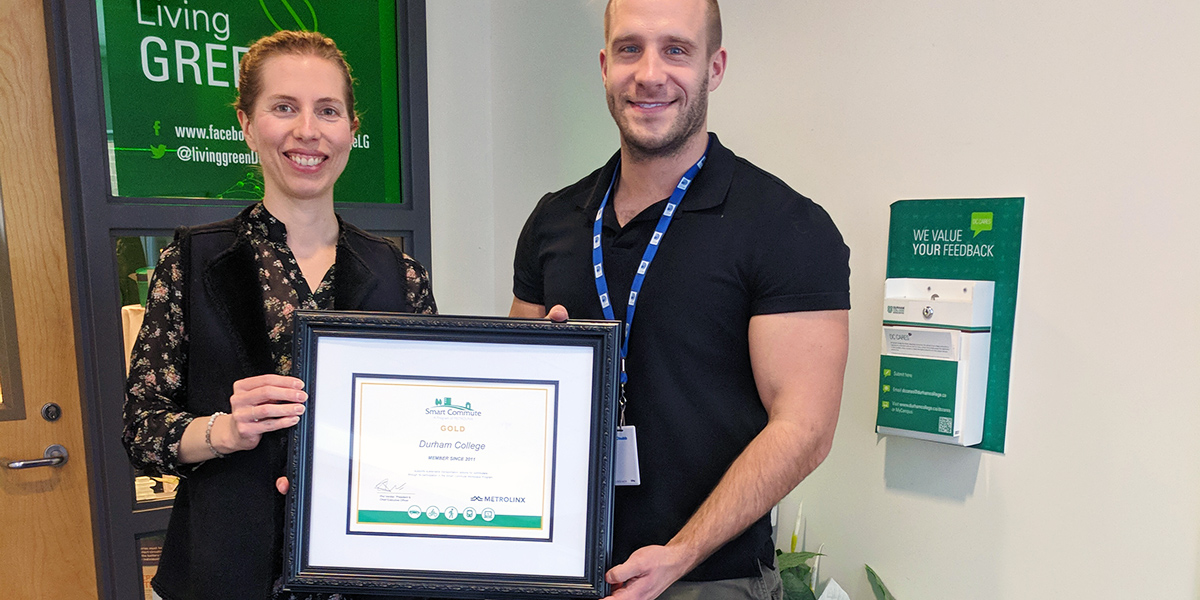 Woman and Man Holding holding smart commute gold plaque presented to Durham College