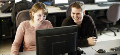 Male and female students in front of a computer