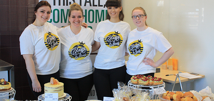 Students pose for photograph at the Bake Shop sale at Whitby campus.