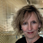 Catherine Davidson, the Chief Librarian, is a white woman with blond hair. She smiles in front of the study hall of the library.