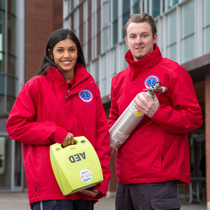 Paramedic students holding paramedic equipment