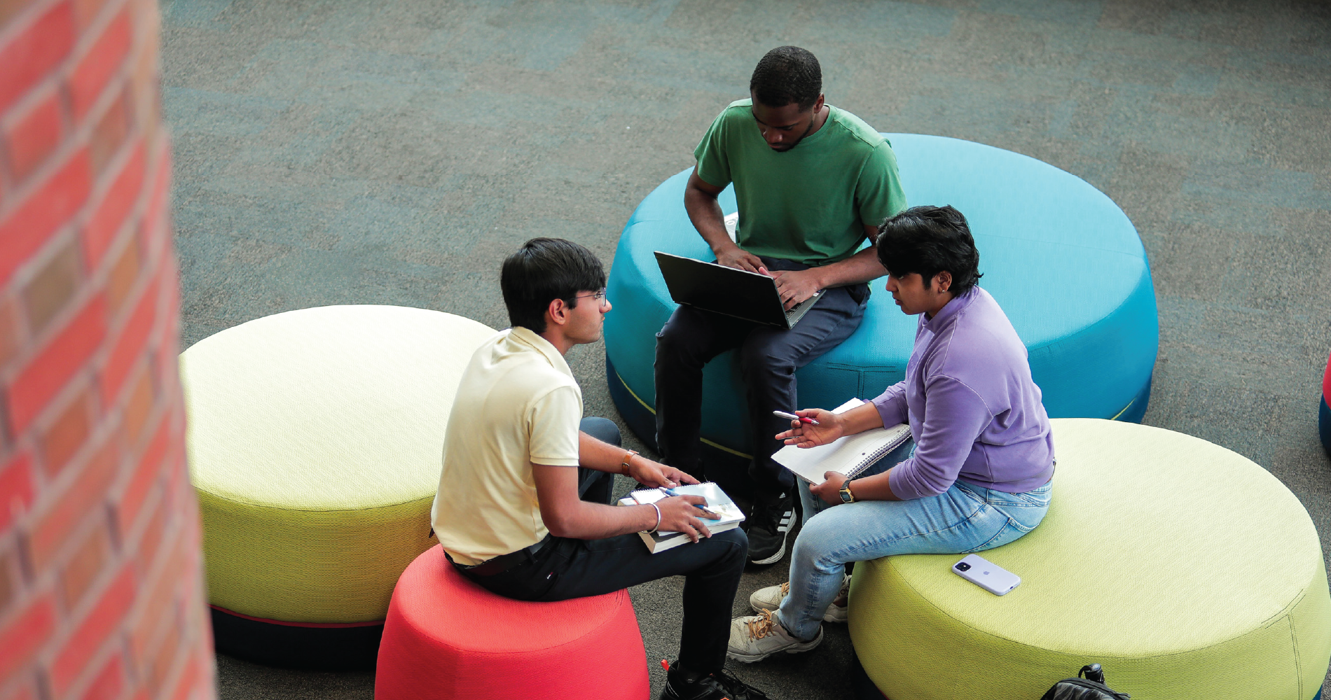 students chat while sitting on comfy seating in the dixon-alger fireside reading room