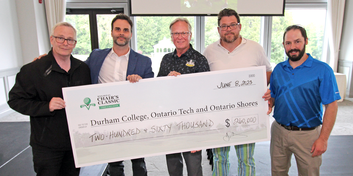 DC president Don Lovisa and others accept a cheque and smile at the camera.