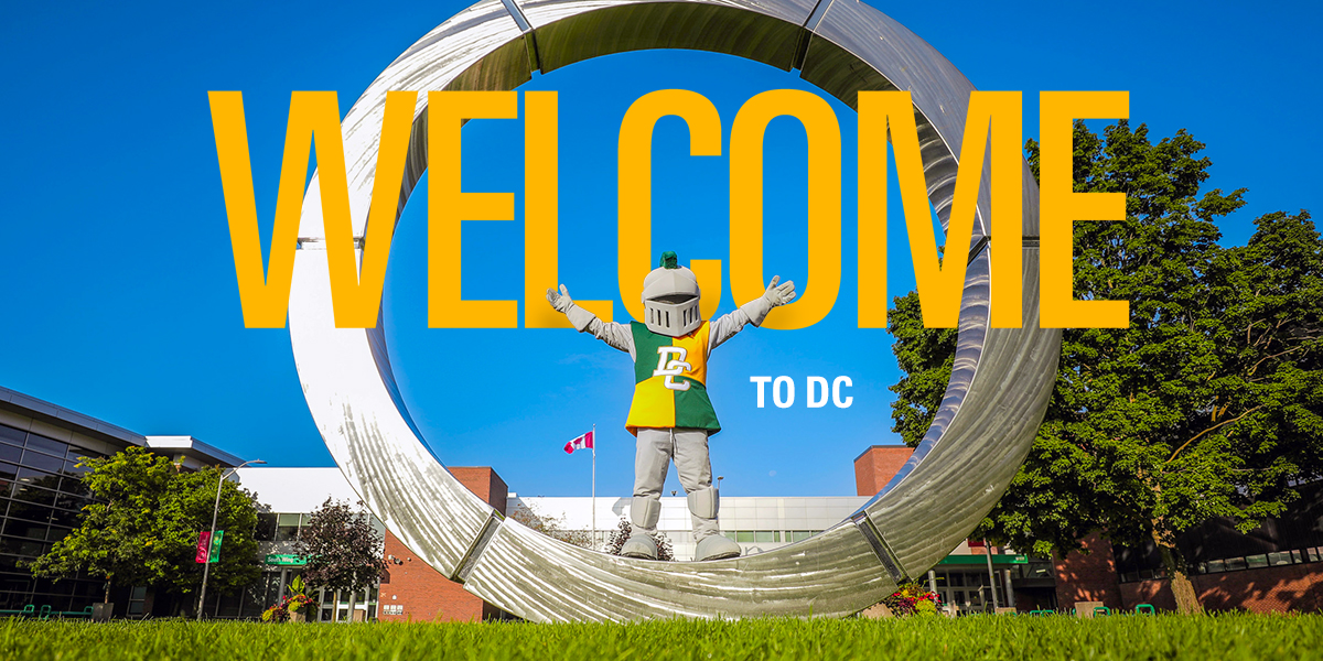 Durham College mascot Lou stands with arms raised inside the silver campus ring sculpture on a sunny day. Large yellow text across the image reads “WELCOME,” with smaller white text below reading “TO DC.”