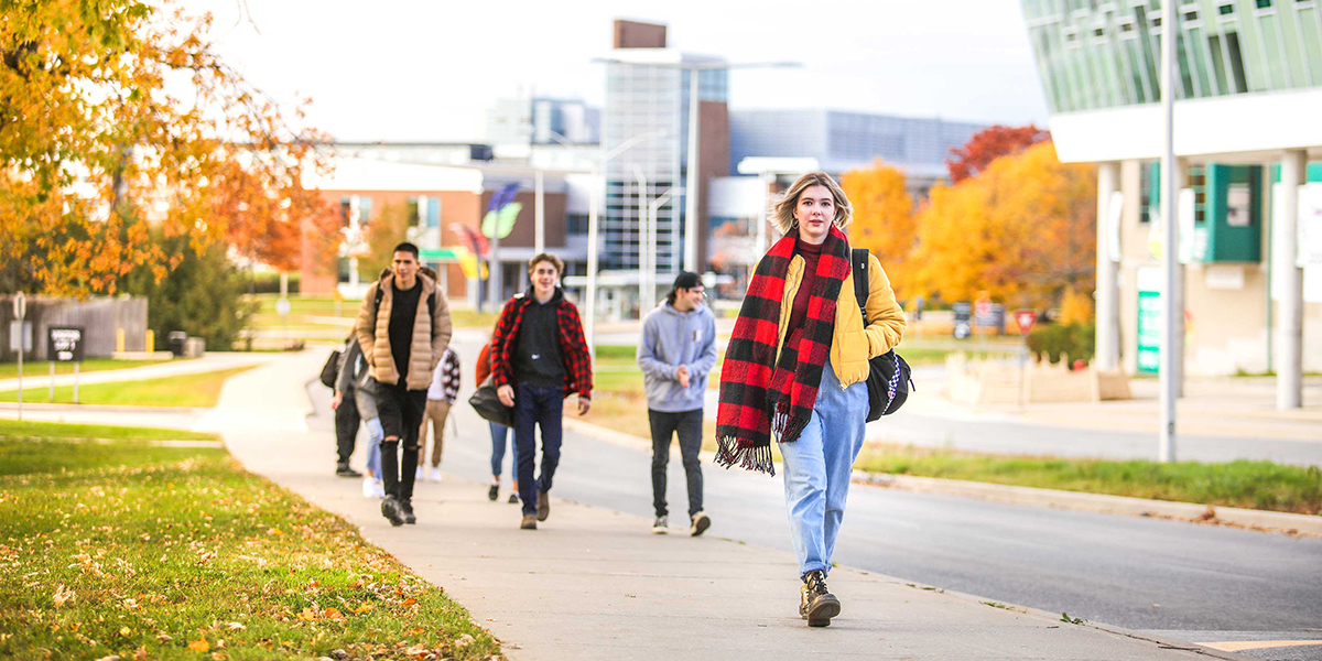 Students walk along a path at Durham College.