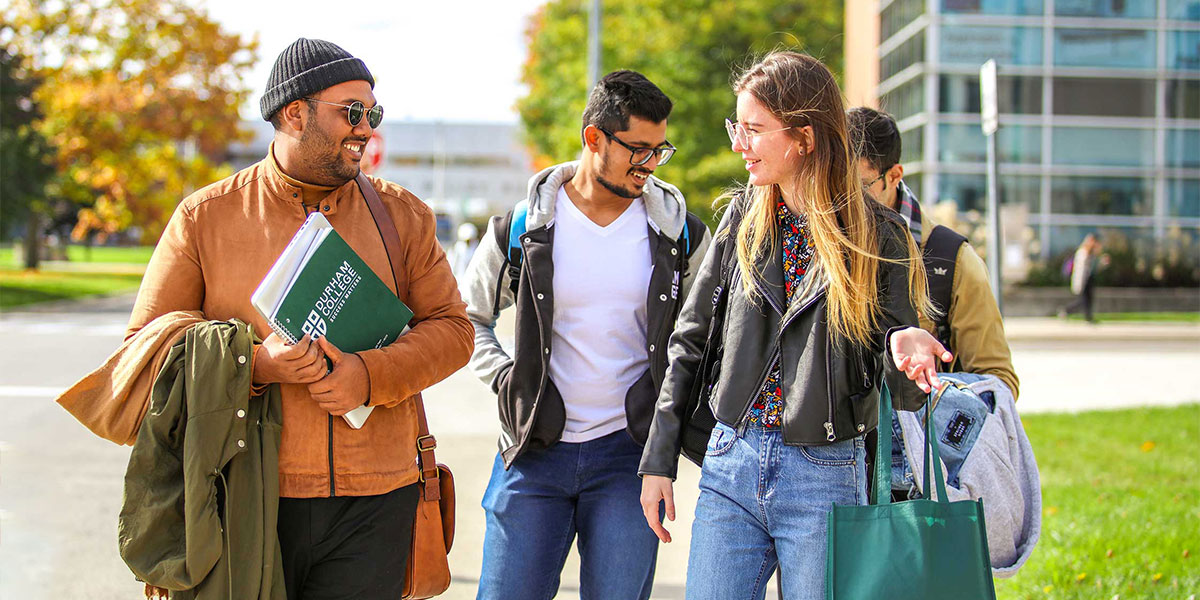 Students smiling while walking on campus.