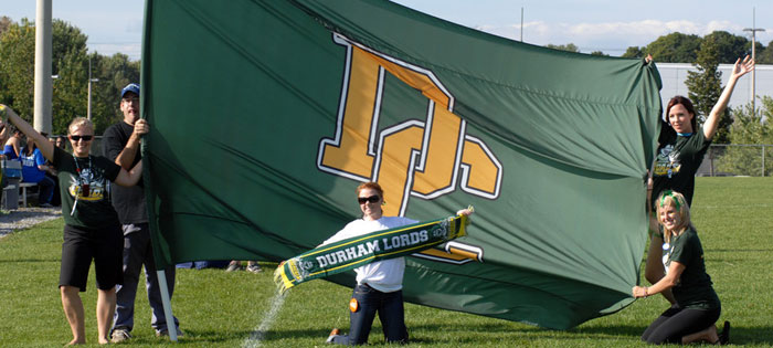 Durham Lords flag held by student athletes